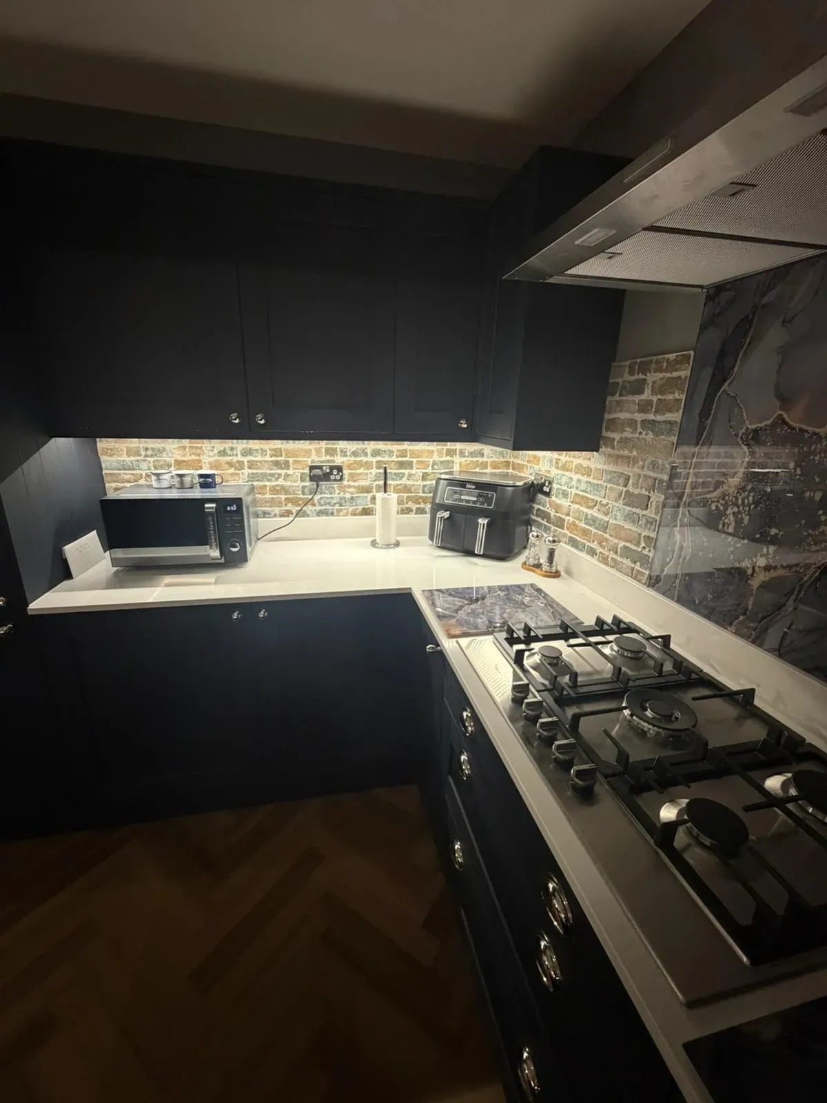 Modern kitchen installation in Felixstowe featuring navy blue cabinetry and under-cabinet lighting by FLEX PROPERTY SERVICES
