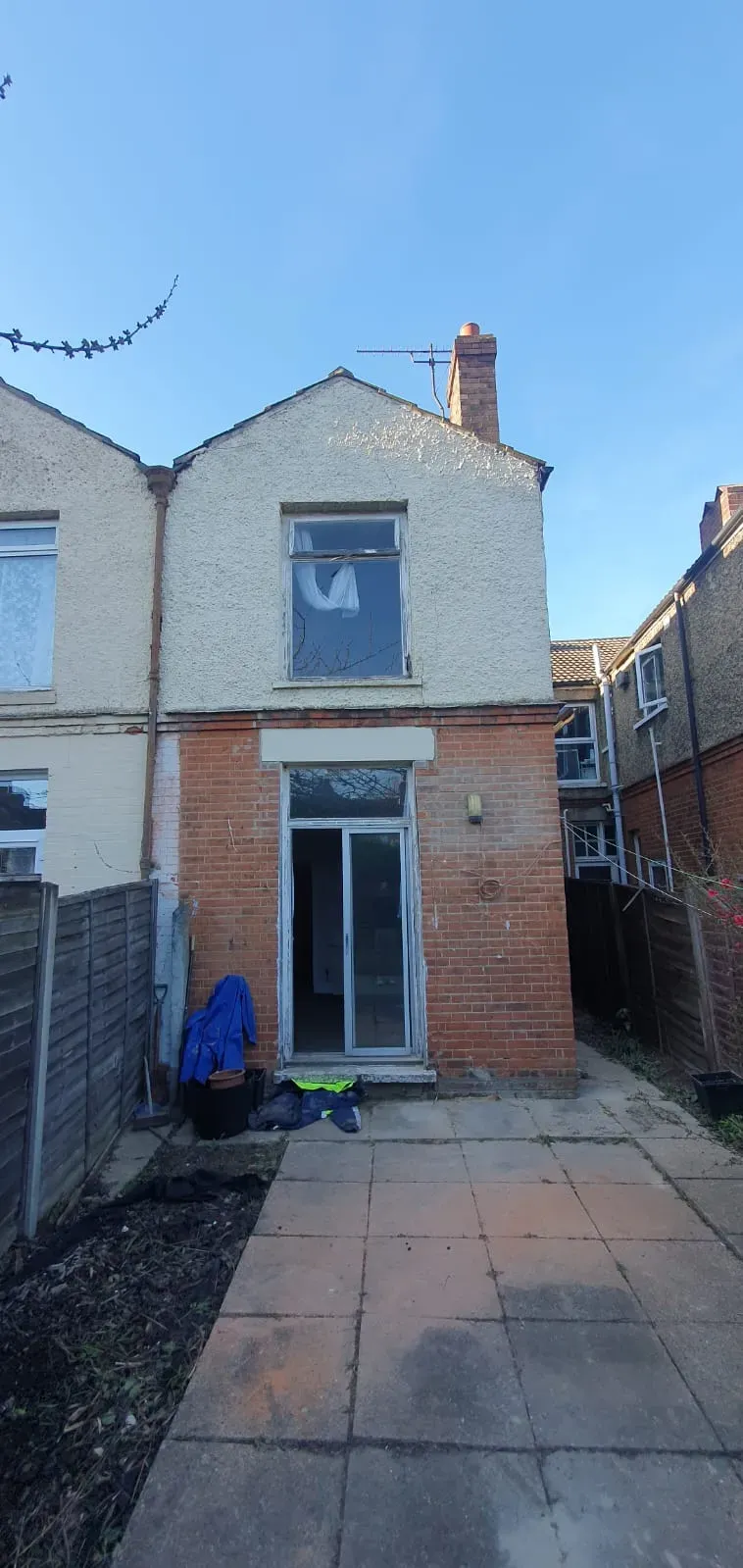Rear view of a house with a patio and sliding doors, showcasing property maintenance services in Suffolk.